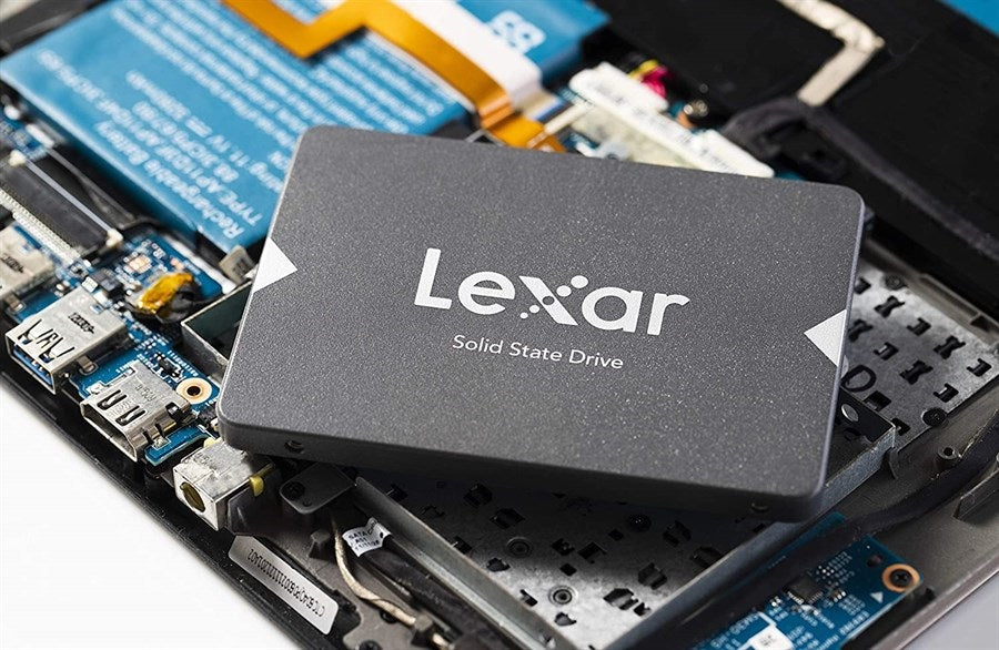 Prime Tech Store Lexar NS100 256GB 2.5-inch SATA SSD with black circuit board and silver label, shown in close-up.